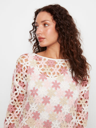 Elegant crochet top in white with pink flowers, showcasing drop shoulders and a stylish design. A creation by Charlie B.