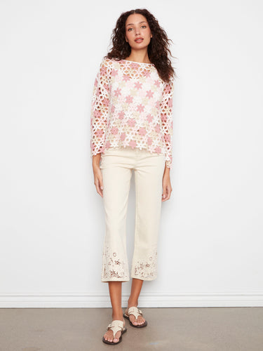 Charming crochet top with pink floral details on a white base, made from a comfortable cotton blend. Designed by Charlie B.