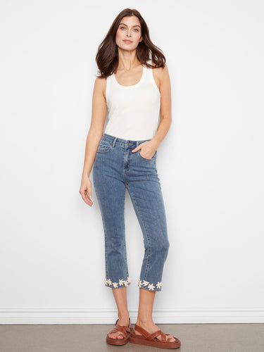 Blue cropped jeans with a slim fit and flared leg, highlighting the floral hem trim for a trendy look by Charlie B.