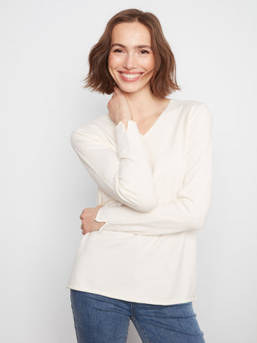 Elegant knit top with a V-neckline, perfect for layering. The soft texture adds comfort and style to any outfit by Charlie B.