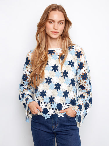 Crochet top with a charming boat neckline, featuring intricate floral patterns and vibrant blue hues. Made with a cotton blend by Charlie B.