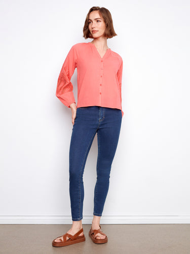 Chic coral blouse with embroidery on sleeves, offering a stylish flair perfect for any occasion. By Charlie B.
