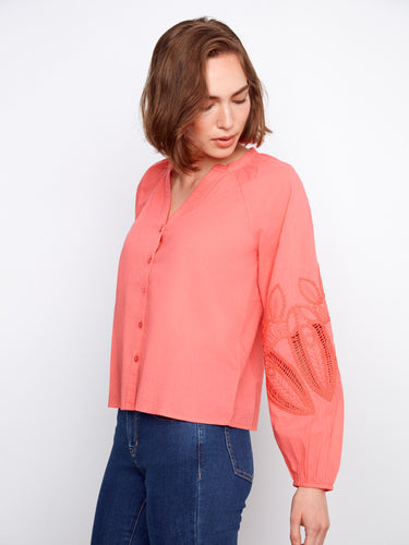 Elegant coral blouse with elastic cuffs for added comfort and style, making it a versatile choice. By Charlie B.