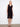 Elegant black dress featuring a V-neckline and sleeveless design, perfect for warm weather occasions. By Charlie B.