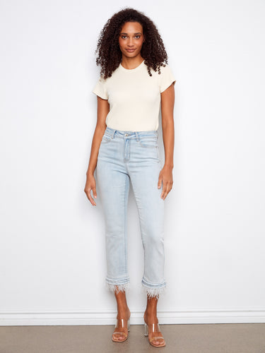 These jeans feature a flared leg design, offering a stylish silhouette with their unique removable feather hem by Charlie B.