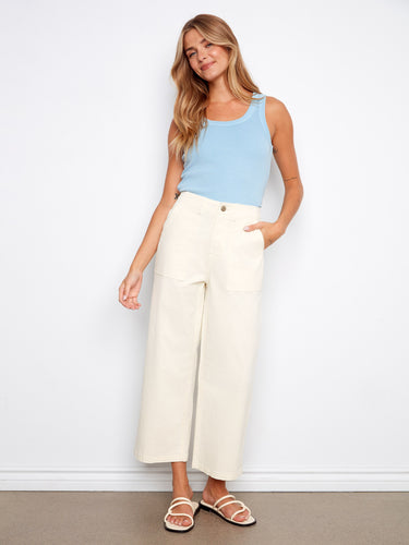 Natural twill pants in a straight fit, paired with a light blue top and sandals by Charlie B.