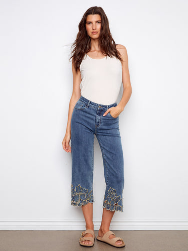 Denim pants featuring a wide fit and cropped length, highlighted by intricate flower embroidery at the hem. By Charlie B.