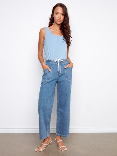 Denim pants featuring a wide leg fit with patch pockets for added style and functionality. By Charlie B.