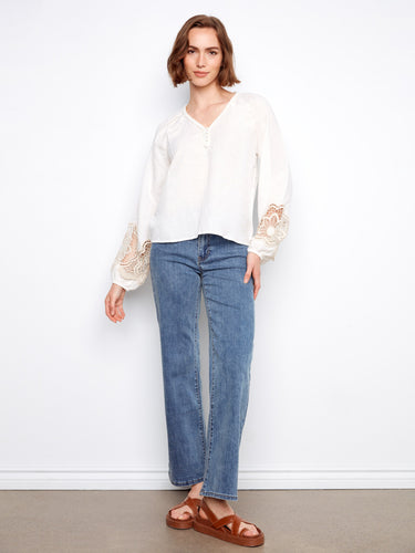 Chic white blouse with decorative buttons and stylish balloon sleeves for a modern look by Charlie B.