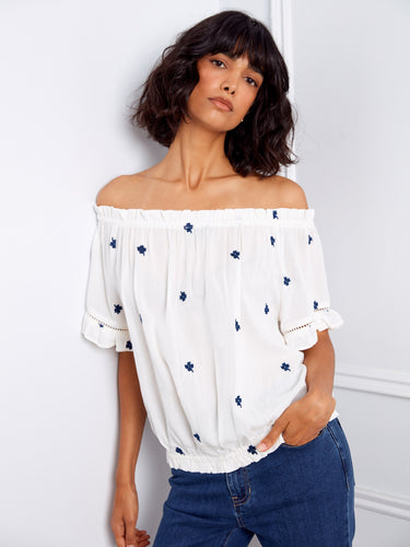Stylish white blouse featuring short flutter sleeves and intricate blue embroidery for a casual look by Charlie B.