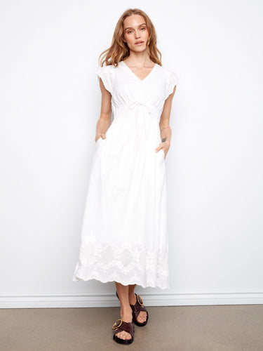 White V-neck dress featuring an empire elastic waist and hidden pockets by Charlie B.