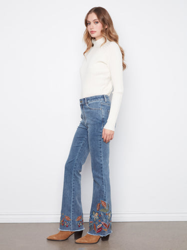 Full-length jeans in stretch denim fabric, offering comfort and style with detailed embroidered accents. Made by Charlie B.