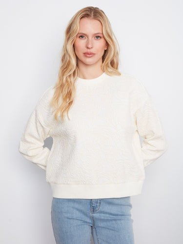 Buttercream sweatshirt with crew neckline and floral soutache design, perfect for a relaxed fit. Crafted with long sleeves by Charlie B.