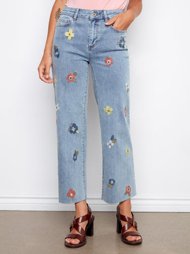 These light blue jeans feature a regular rise and vibrant floral designs for a chic look by Charlie B.