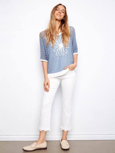Chic blue top featuring elbow dolman sleeves and intricate floral appliqué for a unique touch. Styled by Charlie B.