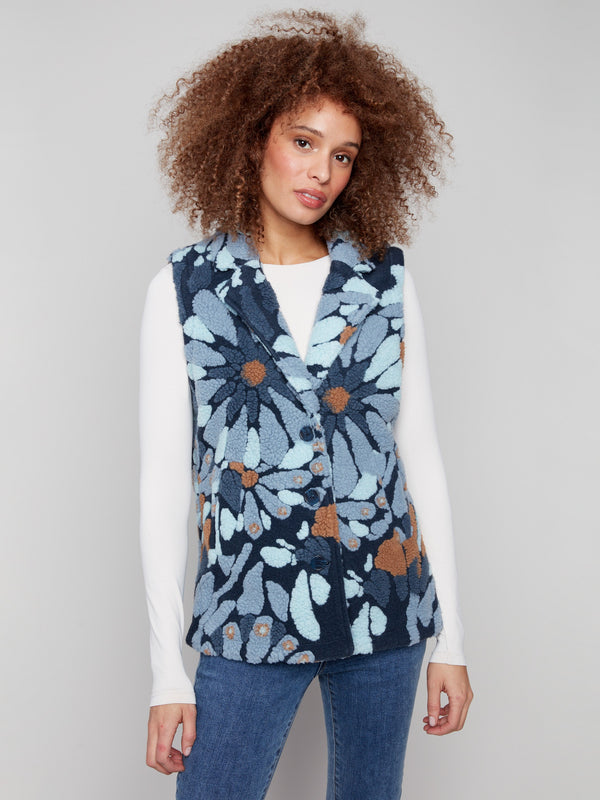 Chic and cozy blue floral Sherpa vest designed with handy two pockets for convenience by Charlie B.