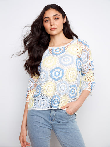 Featuring a stylish crew neckline, this top showcases a vibrant handcrafted crochet design in pastel hues. By Charlie B.