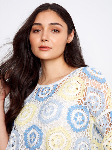 The 3/4 sleeves of this top complement its intricate crochet pattern, offering both style and comfort. By Charlie B.