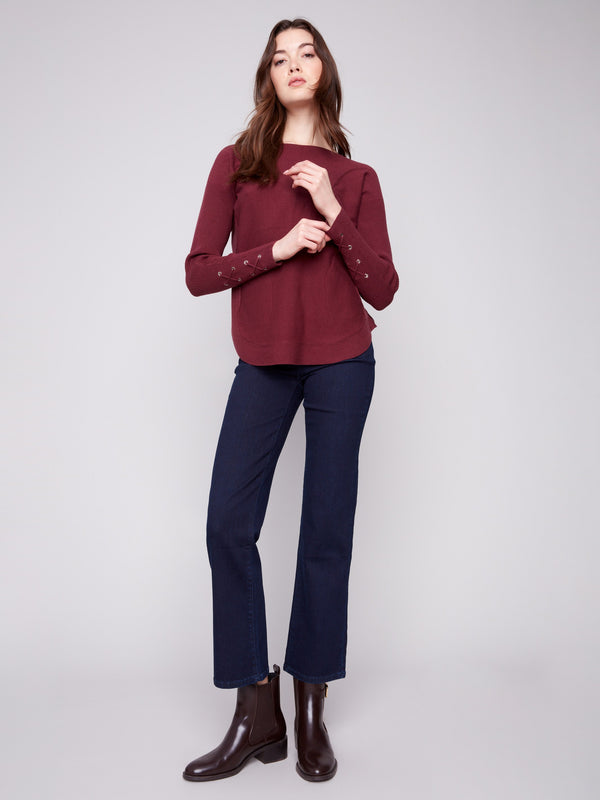 Elegant knit sweater in cabernet with rounded hem and lace-up cuff detail for added flair by Charlie B.