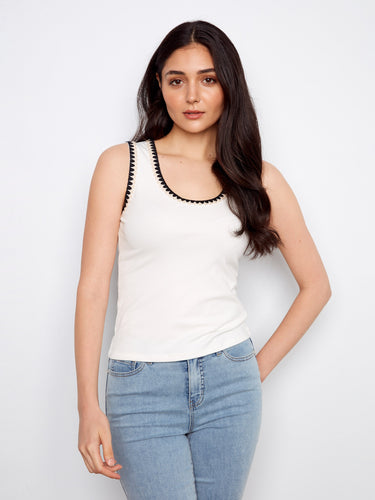 White sleeveless top featuring a stylish scoop neckline, perfect for warm weather outfits. Designed by Charlie B.