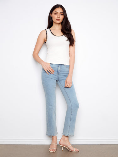 Elegant white top with intricate crochet detail along the neckline, adding a touch of sophistication. By Charlie B.
