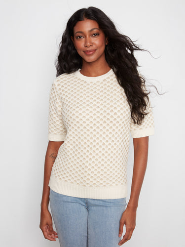 This top features a classic crew neck design, perfect for any casual outing. The intricate detailing adds a touch of elegance by Charlie B.