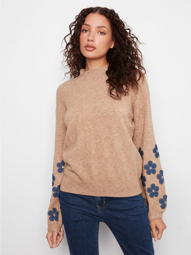 Sweater with a cozy mock neck design, enhanced by floral patches along the sleeves for a charming touch. By Charlie B.