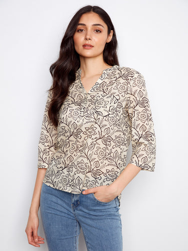 Embrace the half-button design of this floral blouse, offering both comfort and chic style in one beautiful piece by Charlie B.