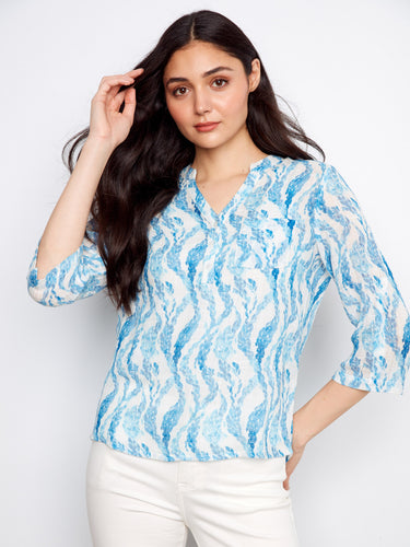 Blue patterned top featuring a stylish Henley neckline and a half-button design, perfect for casual outings. By Charlie B.