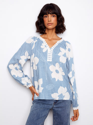 Blue floral blouse with a delicate crochet trim at the neckline, adding a touch of elegance to the overall design by Charlie B.