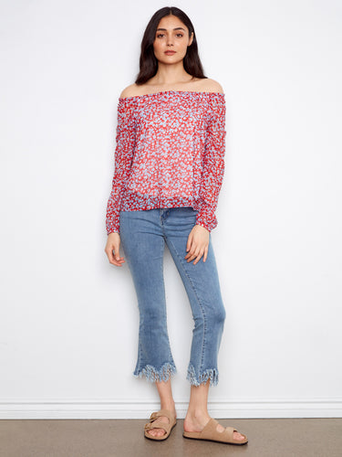 Stylish off-shoulder red blouse featuring elegant balloon sleeves and floral pattern, styled with denim jeans by Charlie B.