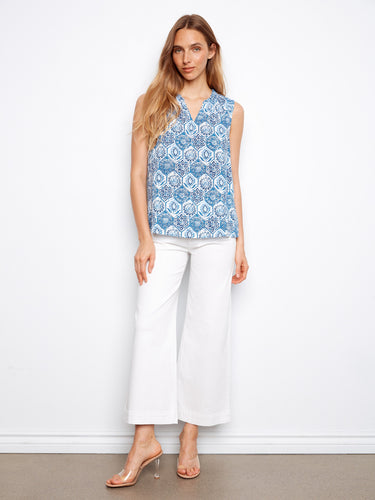 Adorned with a ruffled neckline, this sleeveless top showcases a beautiful geometric print in shades of blue. By Charlie B.