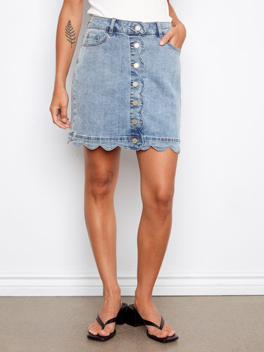 Stylish denim skirt showcasing its scalloped hem design, paired effortlessly with casual sandals by Charlie B.