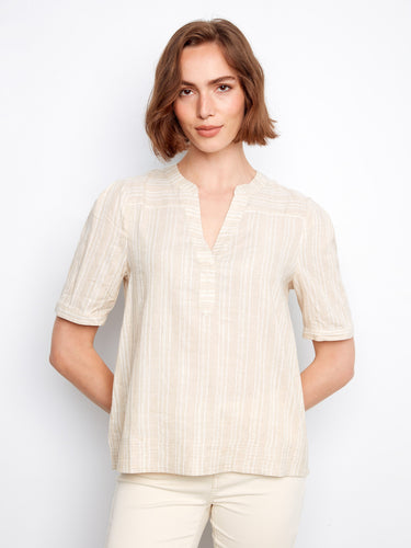 Light beige blouse featuring a henley neckline with subtle gold stripe accents by Charlie B.