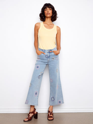 Denim jeans with pixelated flower embroidery, featuring a wide leg design for a trendy look. By Charlie B.
