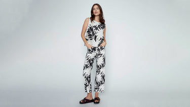 Woman wearing a sleeveless linen blouse with wide-leg cropped linen pants.