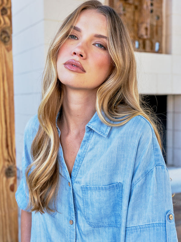 Trendy light blue short sleeve top with subtle details and button-front closure, enhancing your wardrobe effortlessly by Charlie B.