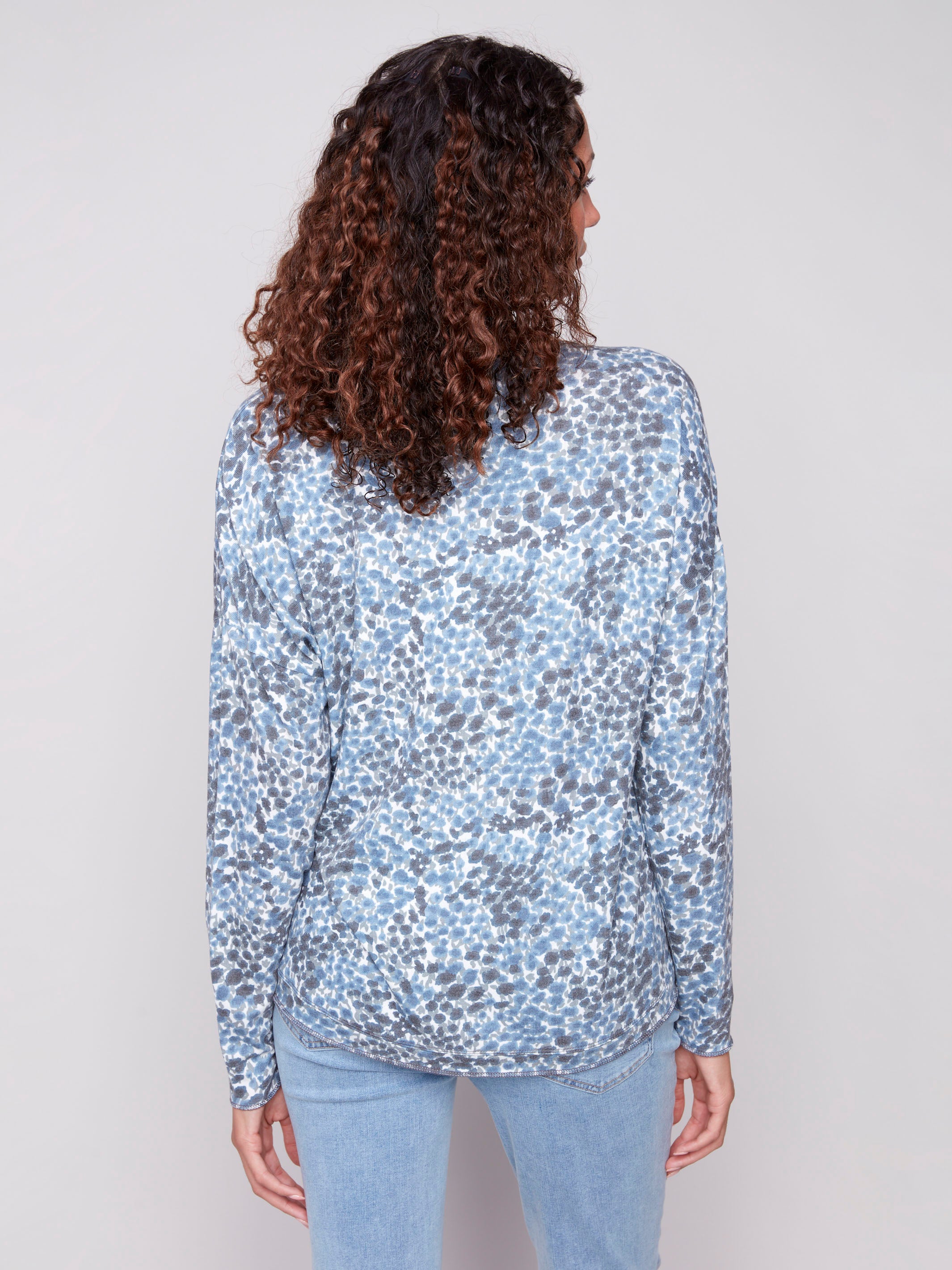 Elegant blue knit top showcasing long sleeves and a beautiful pattern design by Charlie B.