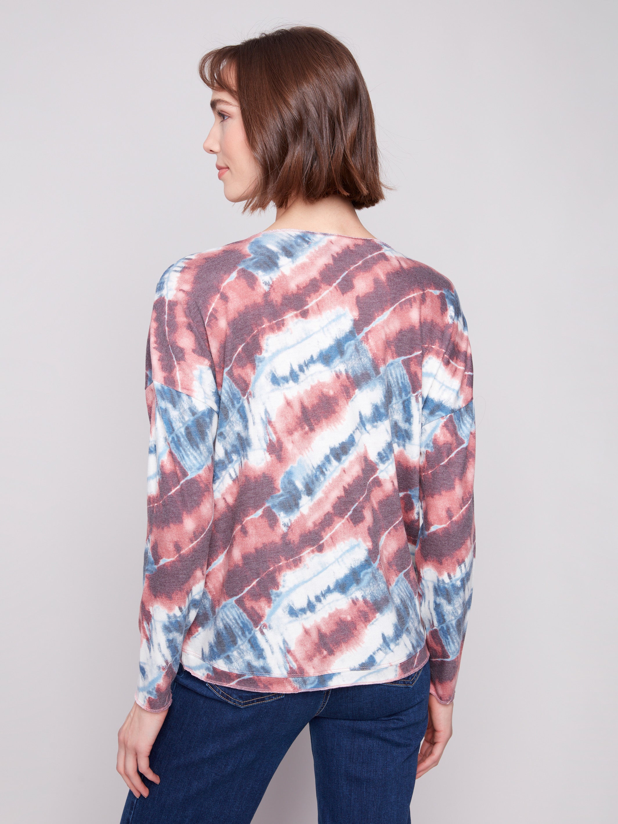 Long sleeves complement the dreamy pink V-neck knit top with unique tie-dye patterning by Charlie B.