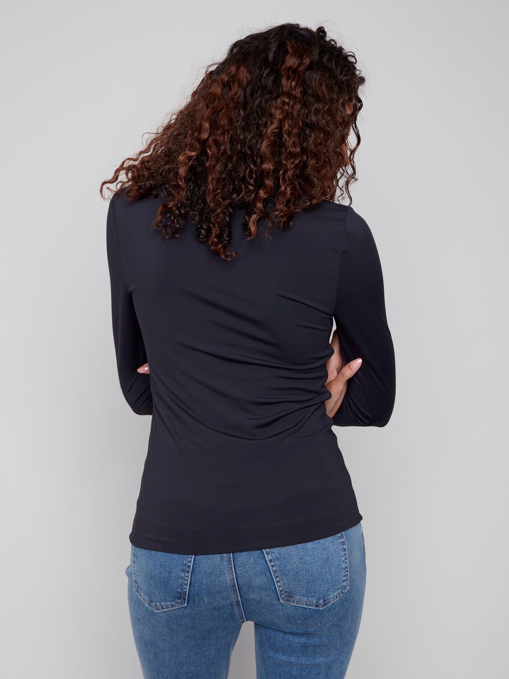 Black long-sleeve top with a crew neck, featuring a sleek fit and super stretchy fabric by Charlie B.