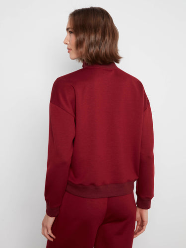 Ribbed hem adds texture to this merlot half-zip sweatshirt, combining elegance with everyday wear by Charlie B.