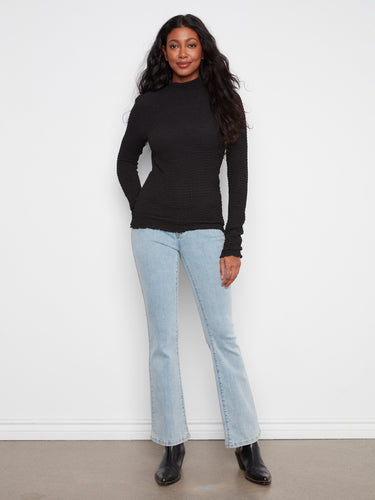 Elegant black knit top with a mock neck and distinctive bubble texture highlighting its style by Charlie B.