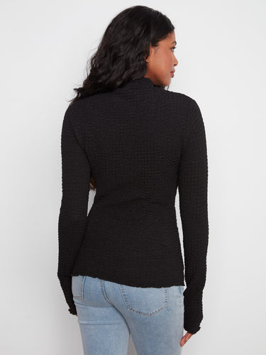 Chic black knit top with lettuce-edge detailing, adding flair to the classic mock neck by Charlie B.