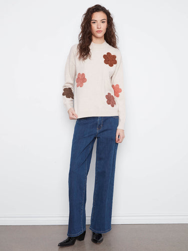 Chic sweater showcasing ribbed cuffs and hem, enhanced by delightful floral appliqué embroidery for added elegance. By Charlie B.