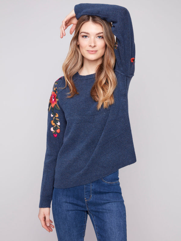Denim sweater featuring knit cuffs and colorful floral embroidery by Charlie B.