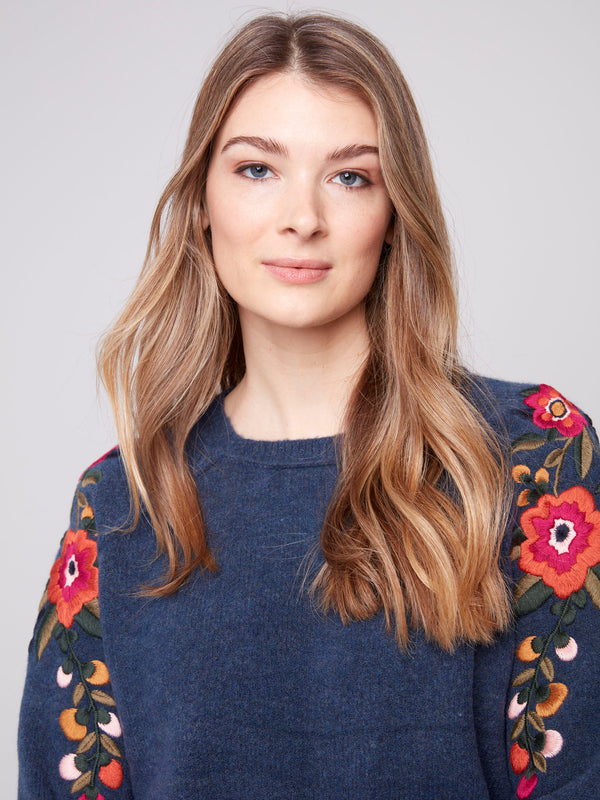 Stylish denim sweater showcasing exquisite floral embroidery and comfortable knit cuffs by Charlie B.