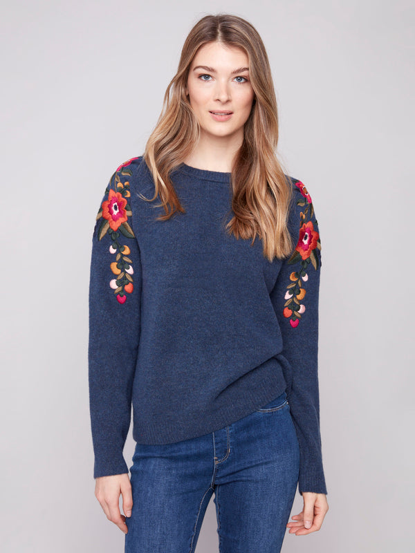 Heather denim sweater with crew neckline and vibrant floral details on sleeves by Charlie B.