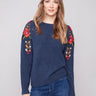 Heather denim sweater with crew neckline and vibrant floral details on sleeves by Charlie B.