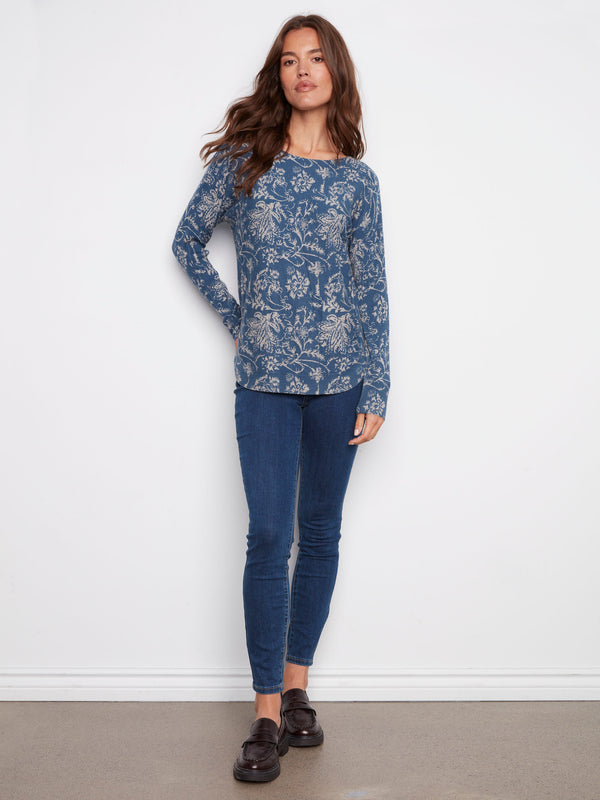 Fashionable calico blue sweater complete with convenient side pockets and artistic florals by Charlie B.