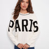 White sweater with crew neck and 'PARIS' boucle embroidery, featuring elegant raglan sleeves by Charlie B.